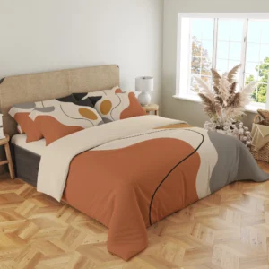 Three-quarter view of terracotta, cream and gray bedding, showing a charcoal curve over the draped front corner and printed pillows by a woven headboard.