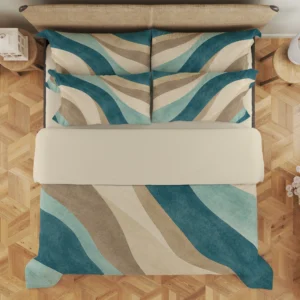 Overhead view of teal, seafoam and sand curved-band bedding with a broad cream fold and four styled printed pillows on a parquet floor.