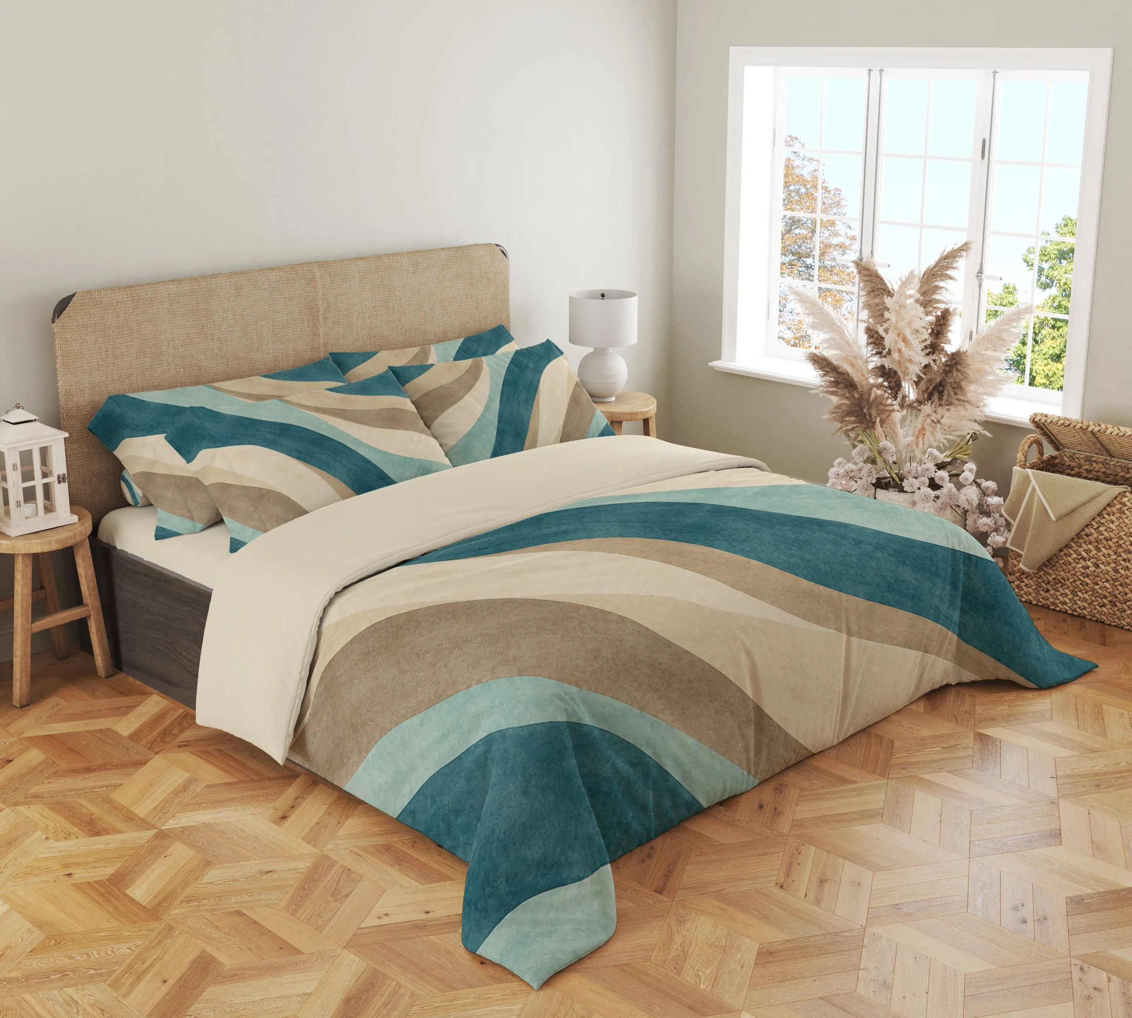Three-quarter view of teal, seafoam and sand banded bedding with printed pillows and curved bands draping over the front corner beside a woven headboard.
