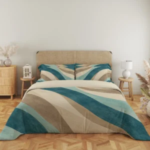 Close frontal view of teal, seafoam and sand curved-band bedding with two printed pillows and a cream fold above the draped duvet.
